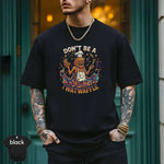 Model wearing black Don't Be a Twatwaffle Shirt with vibrant print and modern fit outside.