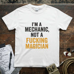 I'm a Mechanic, Not a F**ing Magician Shirt displayed on a wooden table with music equipment.