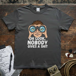 Oh Look, Nobody Gives a Shit Shirt featuring a cartoon character with binoculars on a gray tee.