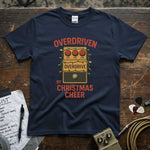 Overdriven by Christmas Cheer Shirt displayed on a wooden table with guitar accessories.