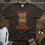 Too Much Gain Not Enough Eggnog Shirt on a brown tee with cool distortion graphic and colorful text
