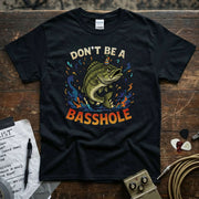 Don’t Be a Basshole Shirt with colorful fish design on a black premium tee by Lucky Spark.