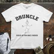 Druncle – Fueled by Fun Since Forever Shirt displayed on a wooden surface with musical accessories.
