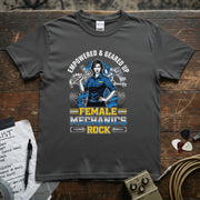 Female Mechanics Rock | Empowered & Geared Up Women Mechanic T-Shirt displayed on a wooden surface with guitar picks.