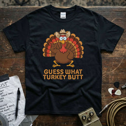Guess What Turkey Butt Shirt featuring a cartoon turkey in a cowboy hat, vibrant design on a black tee.