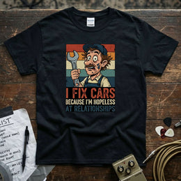 I Fix Cars Because I’m Hopeless at Relationships | Funny Mechanic T-Shirt displayed on a dark background