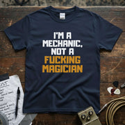 I'm a Mechanic, Not a F**ing Magician Shirt displayed on a navy tee, showcasing vibrant printed text.