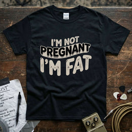 I’m Not Pregnant, I’m Fat Shirt displayed on a black background with guitar accessories.