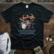 Image of a black shirt featuring a drummer in action with the text 'PROFESSIONAL NOISEMAKER' for musicians.