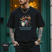 Professional Noisemaker | Funny Drummer Musician Shirt worn by a stylish man with tattoos, sporting a bold drumming design.