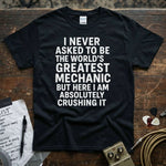 World’s Greatest Mechanic Shirt displayed on a wooden surface with text saying I never asked to be the world's greatest mechanic.